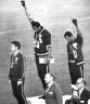 Афроамериканские атлеты Томми Смит и Джон Карлос поднимают кулаки в жесте солидарности. Олимпийских Игры, 1968 год.   