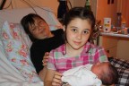 Внучка-Сонька с кем-то из младших сестер на руках. Лера на заднем фоне. Несколько минут после родов. 