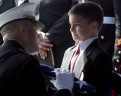 Восьмилетний Кристиан принимает флаг во время поминальной службы по его отцу. Который был убит в патруле в Ираке, всего за несколько недель до того, как он был должен возвратиться домой. 