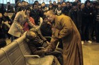 Монах рядом с пожилым человеком, который внезапно умер, ожидая поезда в Шаньси Тайюань, Китай.   